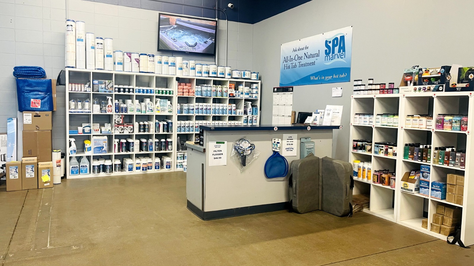Showroom shelves stocked with filters, chemicals, and spa accessories